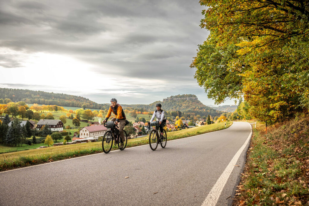 Fahrradfahrer auf der Rockhead Fahrradtour, im Hintergrund die Festung Königstein
